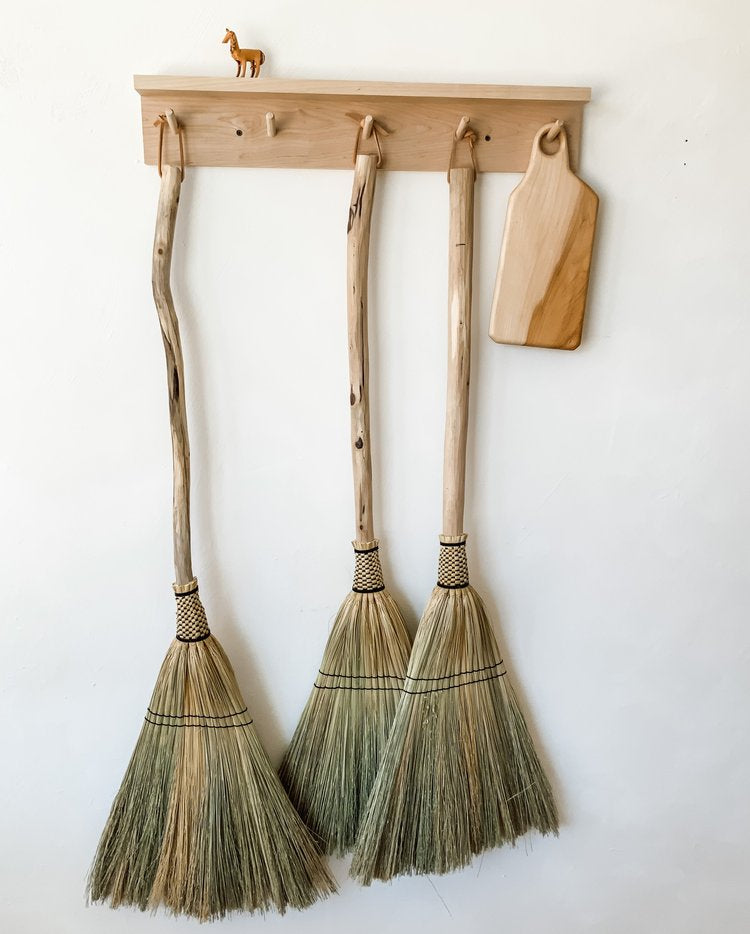 Three-brooms-and-board-hanging-on-the-wall