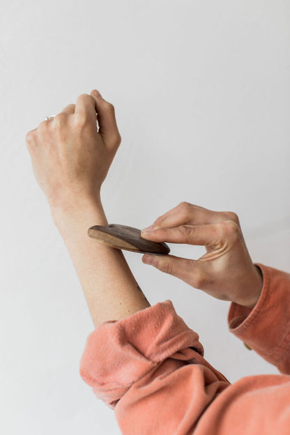 Wooden-gua-sha-scraper-being-used-on-arm