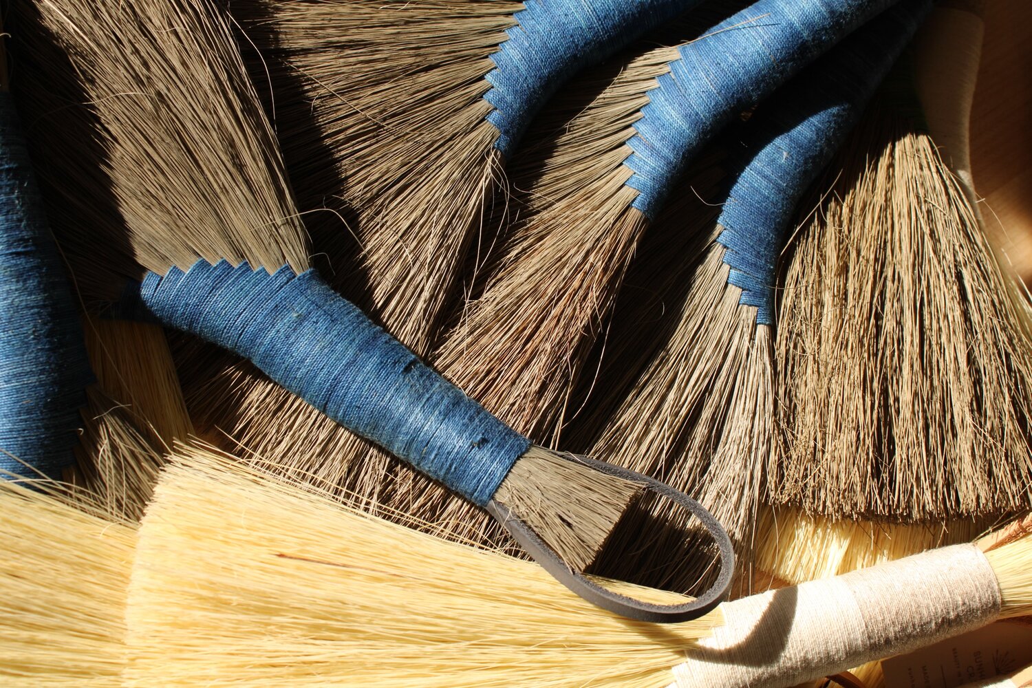 Many-dark-tampico-and-tampico-handbrooms-with-indigo-and-white-threaded-handles