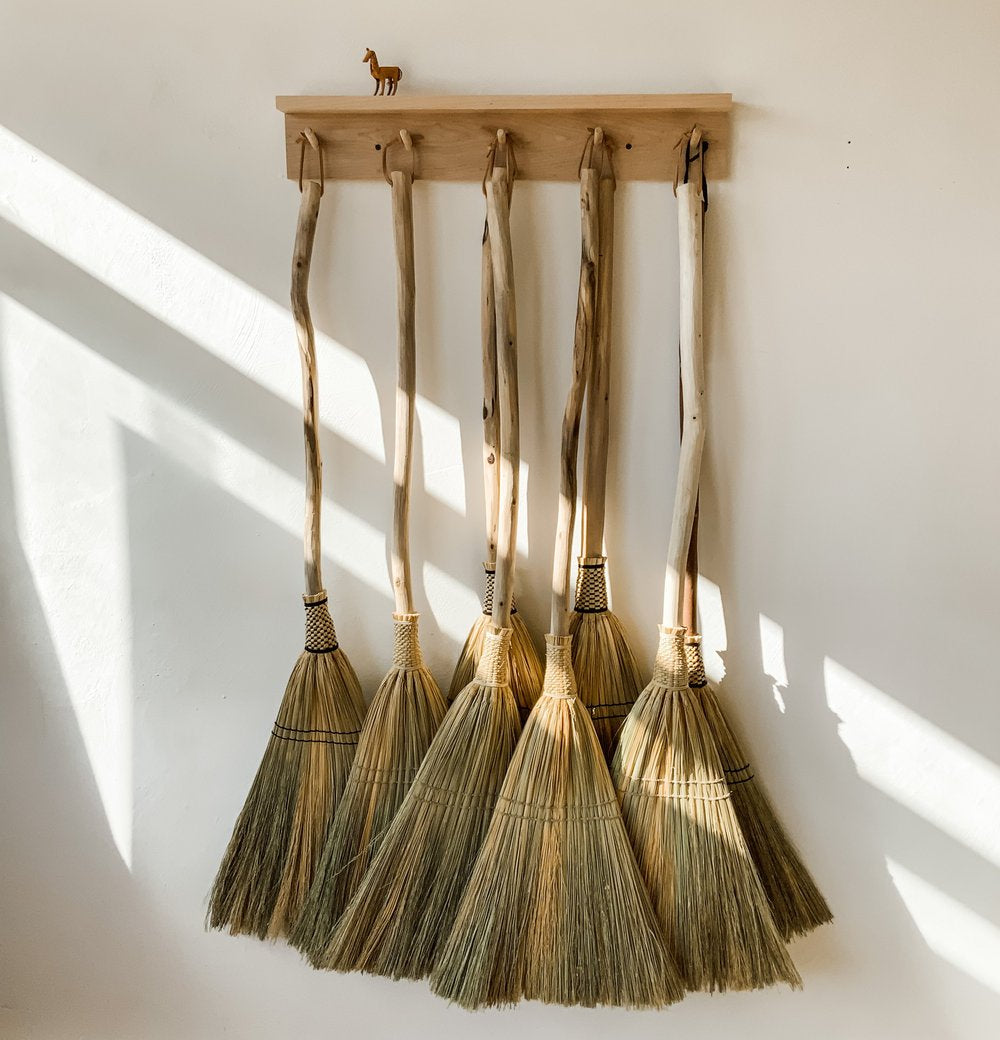 Row-of-brooms-hanging-on-the-wall