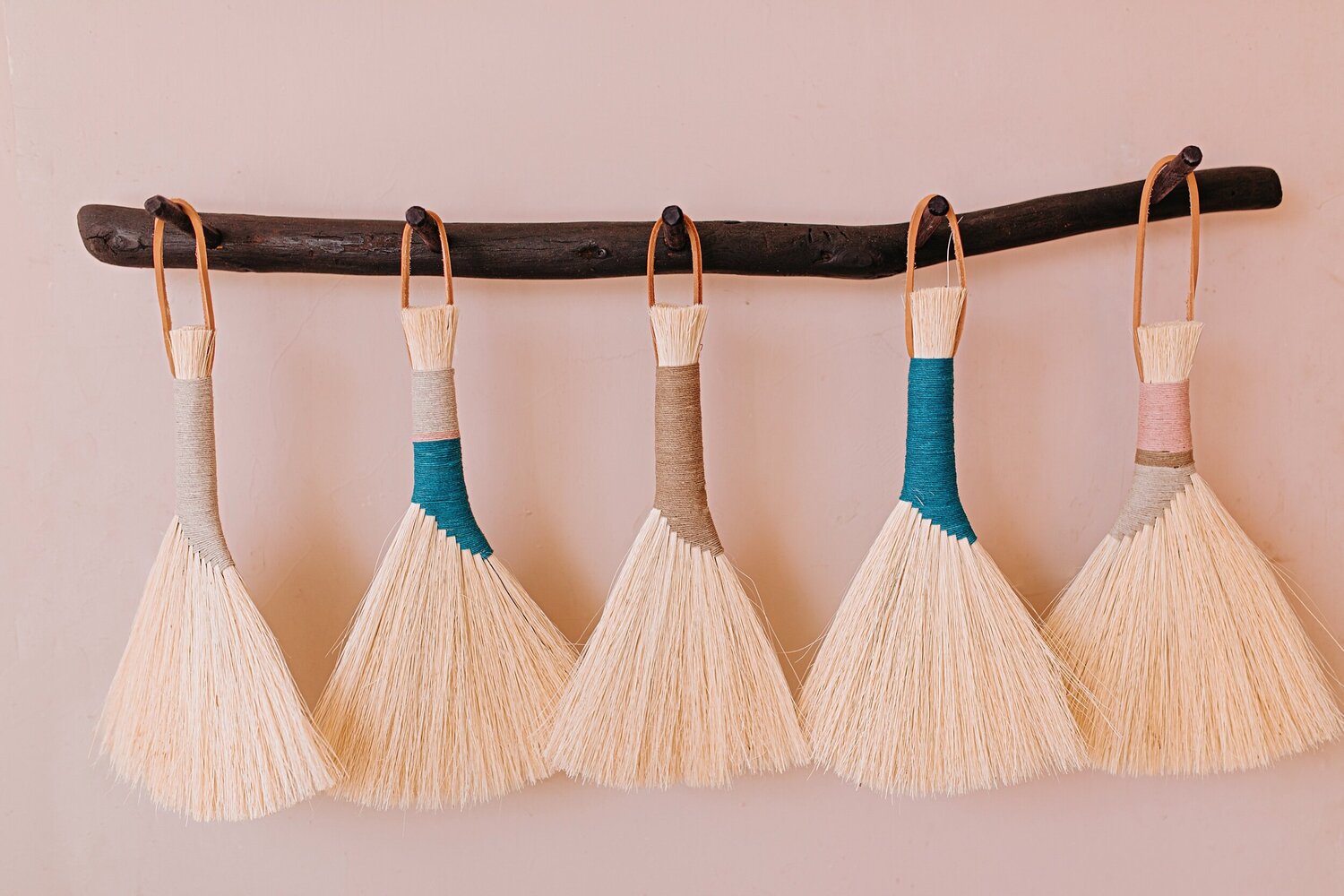 Black-peg-rack-with-turkey-wing-brooms-hanging-on-it