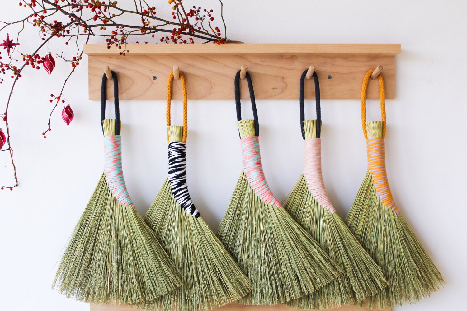 Row-of-handbrooms-on-wall-with-two-tone-threaded-handles